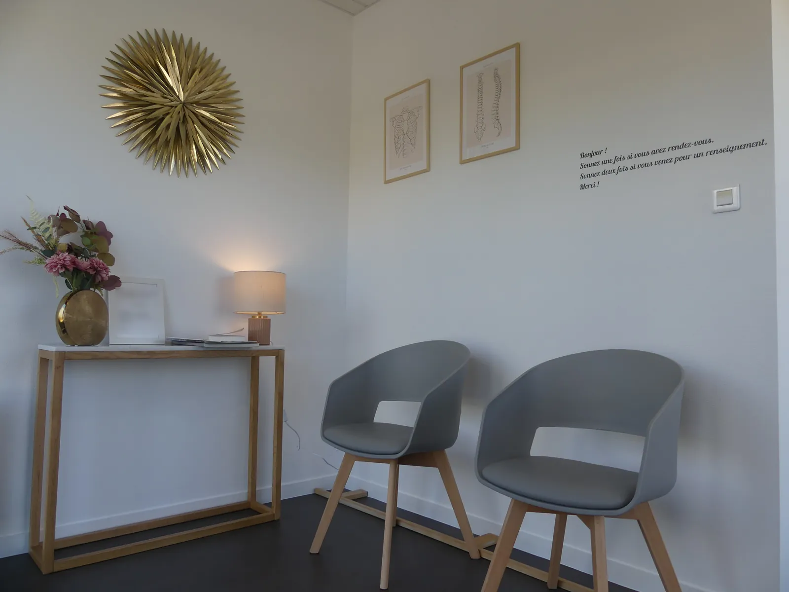 Salle d'attente du cabinet d'ostéopathie à Rioz, avec son miroir soleil doré